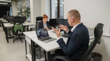 İş ortakları bir video görüşmesiyle işaret diliyle konuşuyor. Uzak bir iş görüşmesinde iki adam.