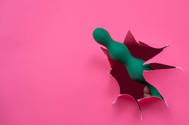 Pembe kağıttan yapılmış yeşil boncuklu kadın eli. Boşluğu kopyala