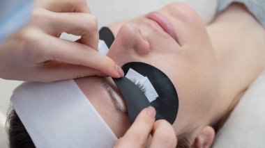 Efendi, LED kirpik uzantılarından önce ultraviyole ışınların içeri girmesine izin vermeyen koruyucu yamalar uyguluyor