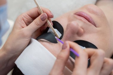 Sahip, uzantılardan önce müşterileri sebum kirpiklerini temizler