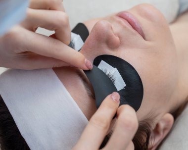 Efendi, LED kirpik uzantılarından önce ultraviyole ışınların içeri girmesine izin vermeyen koruyucu yamalar uyguluyor