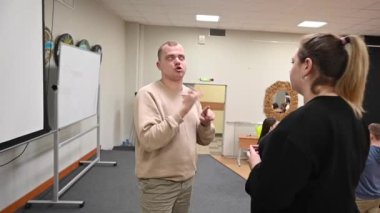 Genç bir kadın ve erkek üniversite sınıfında işaret diliyle iletişim kurarlar.