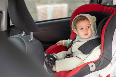 Araba koltuğunda beyaz bir çocuk var.