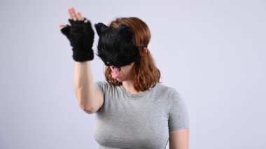 Beyaz arka planda kedi kostümü giymiş bir kadının portresi. Kuadrober