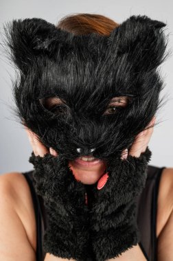 Beyaz arka planda kedi kostümü giymiş bir kadının portresi. Kuadrober. Dikey fotoğraf