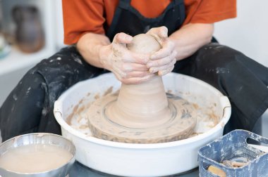 Çömlek çarkında çalışan çömlekçilerin yakın çekimi.