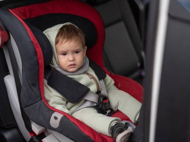 Araba koltuğunda beyaz bir çocuk var.