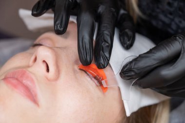 Beyaz kadın kirpik temizleme prosedüründen geçiyor.