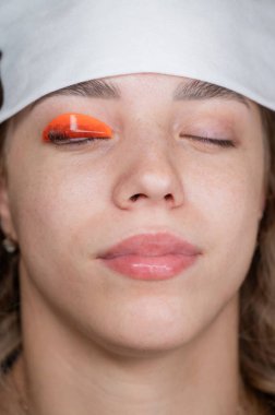 Beyaz kadın kirpik temizleme prosedüründen geçiyor.