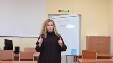 Beyaz kadın üniversitede işaret dili öğretiyor.
