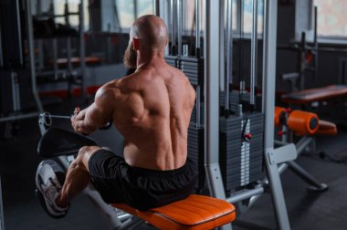 Kürek çekme makinesinde kürek çeken beyaz bir adam.