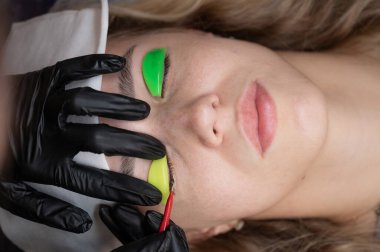 Beyaz kadın kirpik temizleme prosedüründen geçiyor.