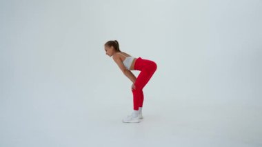 Beyaz arka plandaki spor egzersizlerinden sonra dinlenen beyaz kadın.