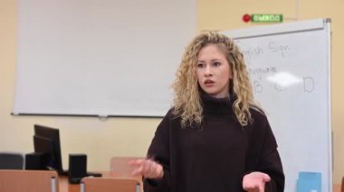 Beyaz kadın üniversitede işaret dili öğretiyor.