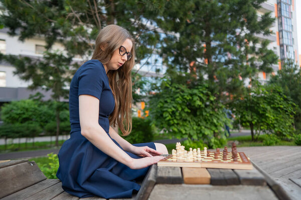 Caucasian woman playing chess outdoors
