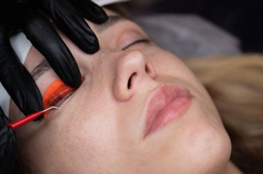 Beyaz kadın kirpik temizleme prosedüründen geçiyor.