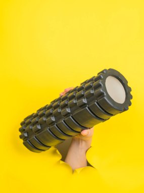Sarı kağıttan yapılmış MFR silindirli bir kadın. Dikey fotoğraf