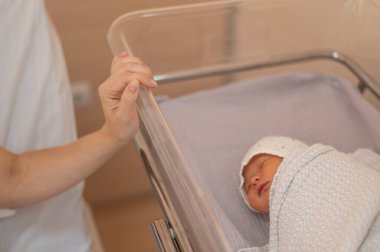 Genç bir anne, doğumevindeki yeni doğan oğluna hayran.
