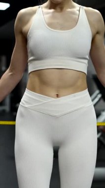 Beyaz kadın spor salonunda kalçalarını ölçüyor.