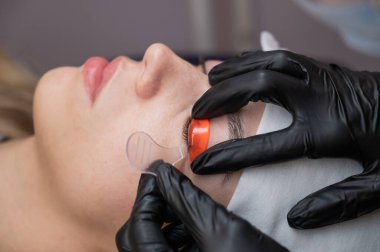 Beyaz kadın kirpik temizleme prosedüründen geçiyor.