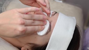 Profesyonel biri kuafördeki pamuk pedi temizlemek için köpük sürer.