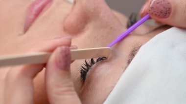 Bir usta bir istemciden kirpik uzantılarını kaldırır