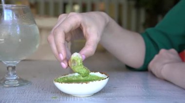 Kafkasyalı kadın ciabatta sosunu kafeye daldırıyor.