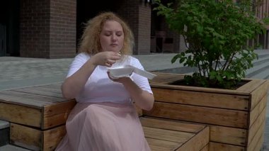 Şişko Kafkas Kadın, elleriyle dışarıda suşi yiyor.