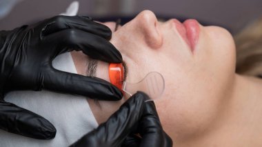 Beyaz kadın kirpik temizleme prosedüründen geçiyor.