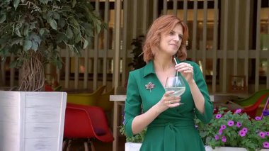 Caddedeki kafede samandan kokteyl içen mutlu beyaz kadın.