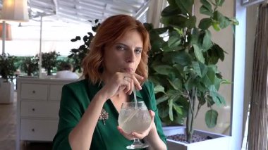 Caddedeki kafede samandan kokteyl içen mutlu beyaz kadın. Yavaş çekim