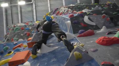 Beyaz adam tırmanma duvarında eğitim görüyor.