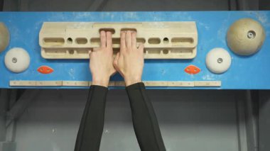 Kaya tırmanışında parmaklarını tahta bir klavyede çalıştıran beyaz bir adam.