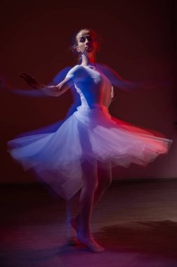 Beyaz kadın balerin eteğiyle klasik dans ediyor. Uzun pozlama fotoğrafı
