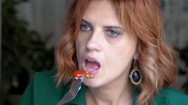 Beyaz kadın yazın kafede salata yiyor.