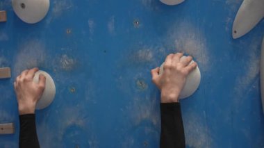 Beyaz adam tırmanma duvarında eğitim görüyor.