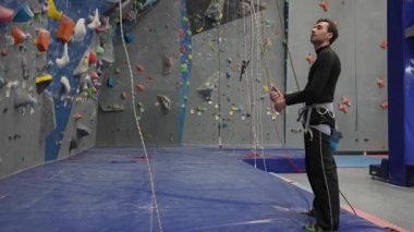 Beyaz adam tırmanma duvarında eğitim görüyor.