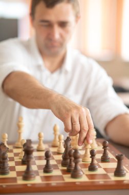 Beyaz adam satranç hamlesi düşünüyor.