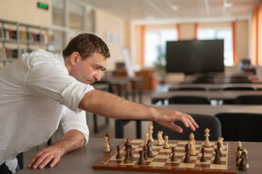 Beyaz adam satranç hamlesi düşünüyor.