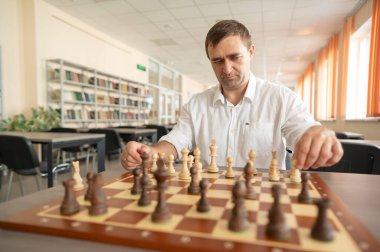 Beyaz adam satranç hamlesi düşünüyor.