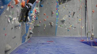 Beyaz adam tırmanma duvarında eğitim görüyor.