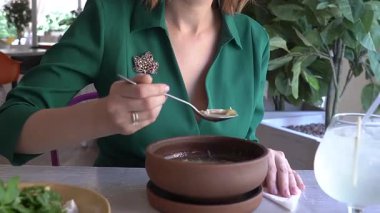 Sokak kafesinde çorba içen mutlu beyaz kadın. Yavaş çekim