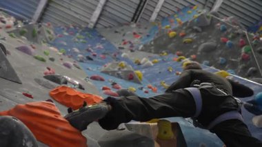 Beyaz adam tırmanma duvarında eğitim görüyor.