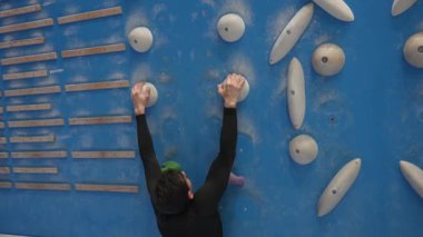Beyaz adam tırmanma duvarında eğitim görüyor.