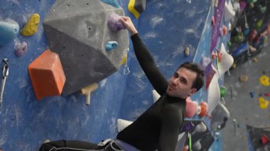 Beyaz adam tırmanma duvarında eğitim görüyor.