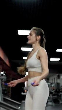 Spor salonunda ip atlayan beyaz kadın.