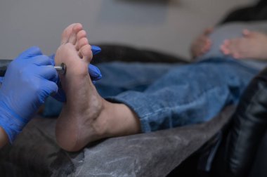 Güzellik salonunda hırdavat pedikür yapan hamile bir kadın.