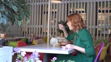 Sokak kafesinde çorba içen mutlu beyaz kadın. Yavaş çekim