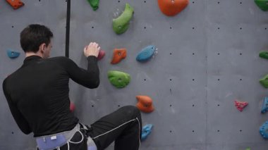 Beyaz adam tırmanma duvarında eğitim görüyor.