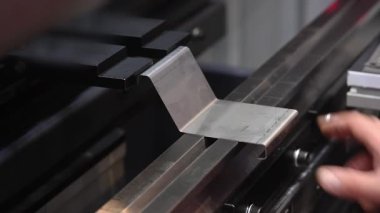Bir usta, bir makinenin metal levhalarını büker. Hidrolik Basınç